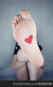 Young woman foot with a heart painted in it