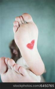 Young woman foot with a heart painted in it