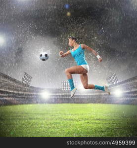 Young woman football player. Image of young woman football player hitting ball