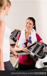 Young woman friends exercising in fitness center on treadmill machine