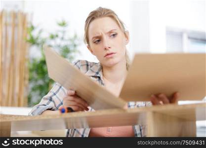 young woman frustrated fixing a furniture