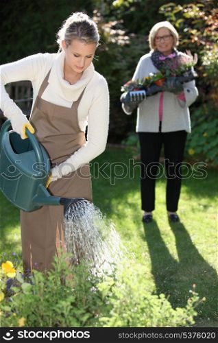 Young woman gardening with her grandmother