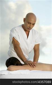 Young woman getting a back massage from a mature man