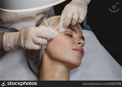 young woman getting beauty procedure wellness center