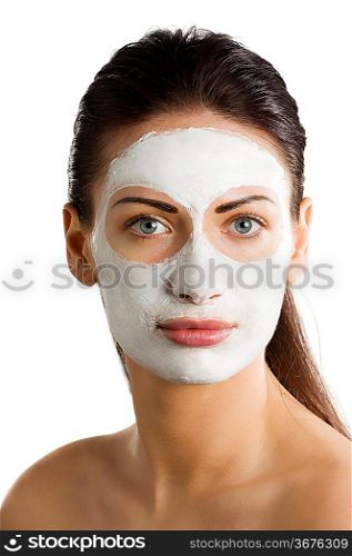 young woman getting beauty skin treatment with a cream mask on her face