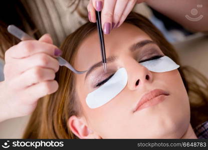 Young woman getting eyelash extension