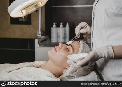 young woman getting face skin treatment spa