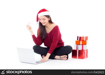 Young woman gift box sitting labtop with internet shopping and holding credit card christmas holiday, girl shoping online on notebook in xmas, celebration concept.