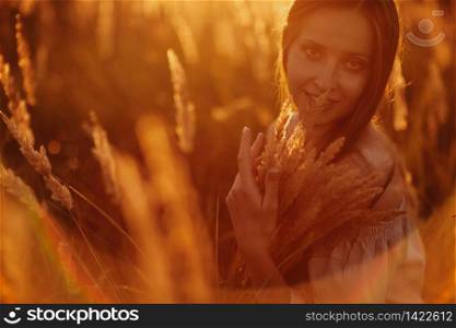 Young woman Girl in field in Sunset in spring, summer landscape background Springtime Summertime. Allergic to pollen of flowers Allergy Backlit Sun Light Autumn Glow Sun Sunshine. selective focus.. Young woman Girl in field in Sunset in spring, summer landscape background Springtime Summertime. Allergic to pollen of flowers Allergy Backlit Sun Light Autumn Glow Sun Sunshine. selective focus