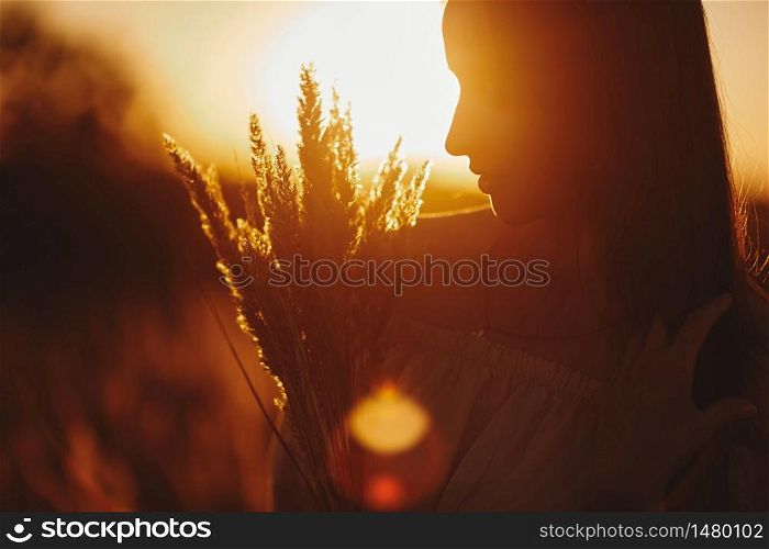 Young woman Girl in field in Sunset in spring, summer landscape background Springtime Summertime. Beautiful smiling woman in a field at sunset. selective focus.. Young woman Girl in field in Sunset in spring, summer landscape background Springtime Summertime. Beautiful smiling woman in a field at sunset. selective focus