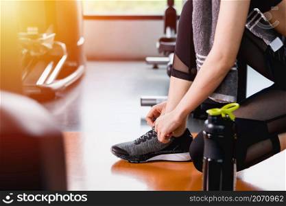 Young woman girl lifestyle sport tied shoelace before training workout exercise cardio at fitness gym