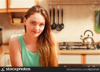 Young woman girl sitting in kitchen waiting for breakfast.. Woman sitting in kitchen.