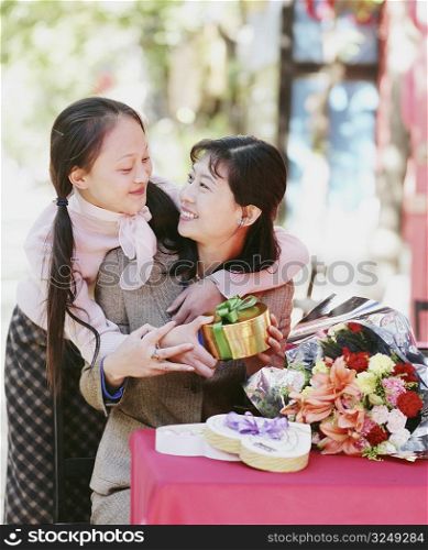 Young woman giving a gift to another woman