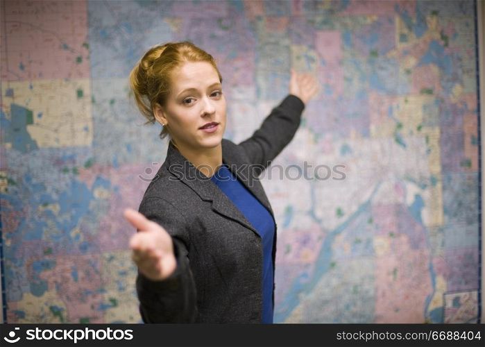 Young woman giving real estate presentation with map