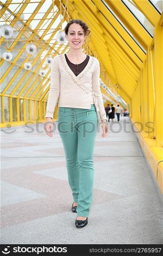 Young woman goes on pedestrian bridge