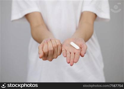 Young woman hands holding different types of feminine hygiene products - tampon and a menstrual cup is stored in her hand.. Young woman hands holding different types of feminine hygiene products - tampon and a menstrual cup is stored in her hand