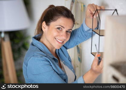 young woman hanging deco on the wall