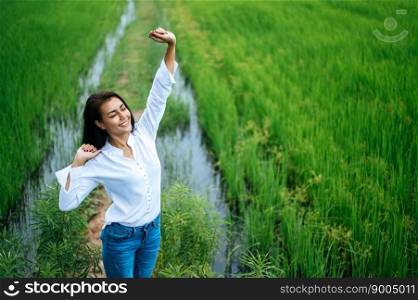 Young woman happily in a green field at sunny day. Happy, health, travel, lifestyle concept.