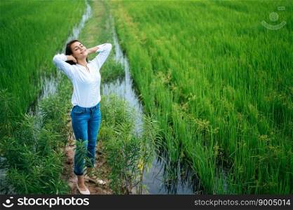 Young woman happily in a green field at sunny day. Happy, health, travel, lifestyle concept.