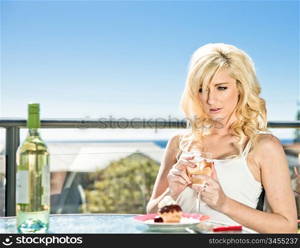 young woman has wine and dessert in cafe