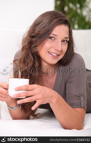 Young woman having a hot drink at home