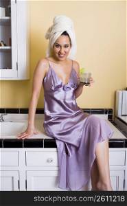 Young woman having a margarita in kitchen