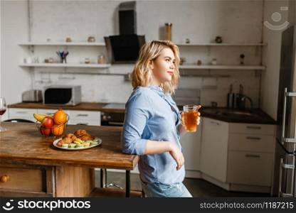 Young woman having breakfast with croissants and cookies. Female person eats dessert on the kitchen, good morning, happy lifestyle