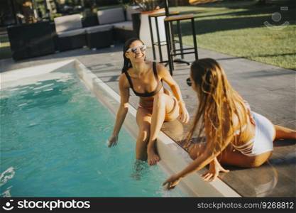 Young woman having fun by the pool at hot summer day