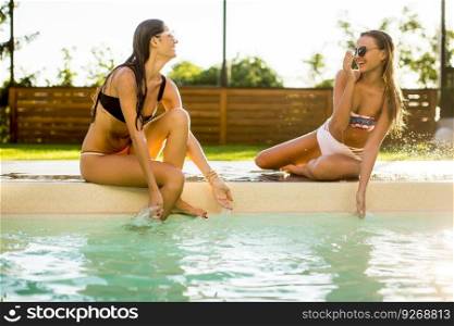 Young woman having fun by the pool at hot summer day
