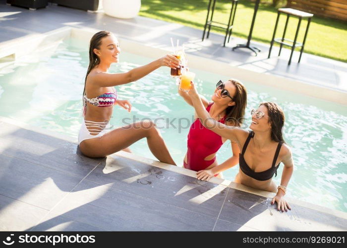 Young woman having fun by the pool at hot summer day