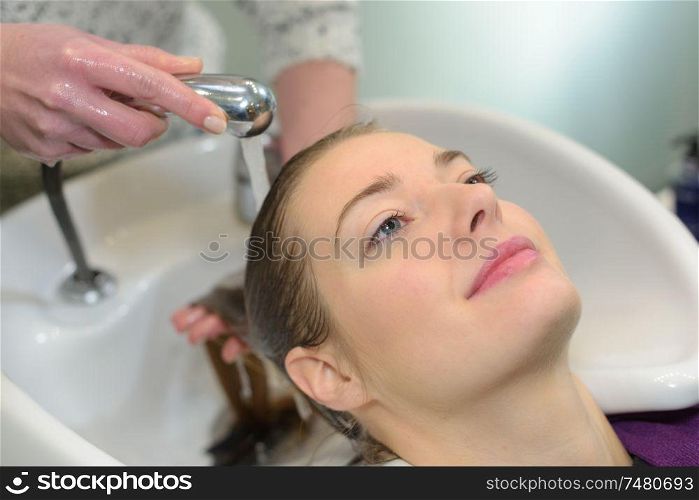 young woman having hair washed in a salon