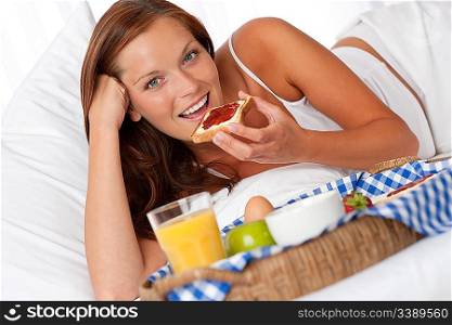 Young woman having home made breakfast in bed