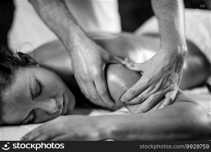 Young woman having relaxing arm and shoulder massage in cosmetology spa center, close up