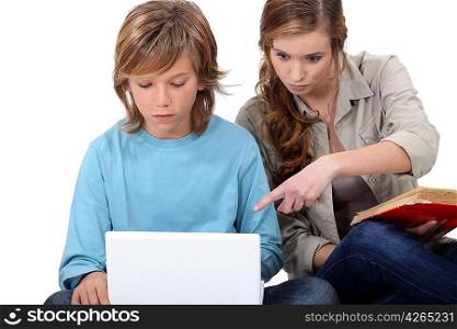 Young woman helping a boy with his computer