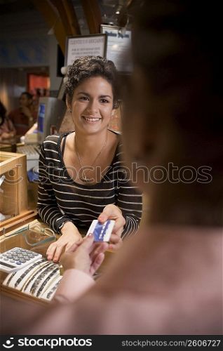 Young woman helping customer in jewelry store