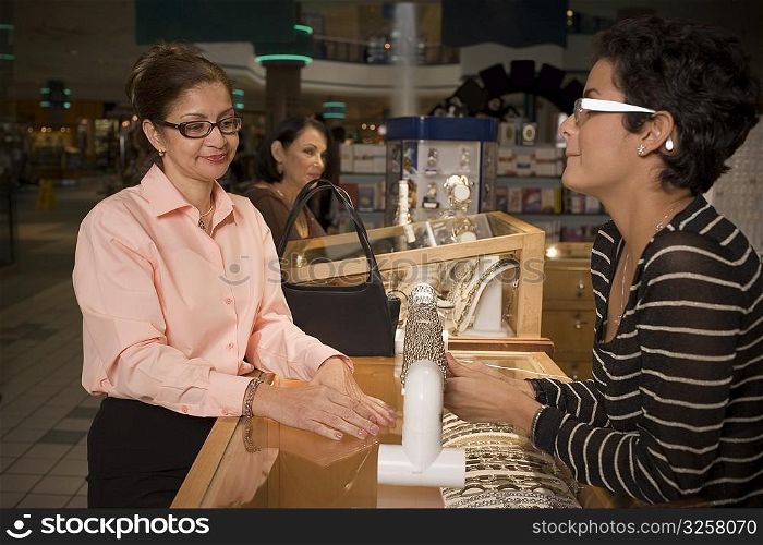 Young woman helping customer in jewelry store