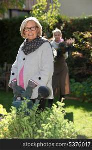 young woman helping senior lady in the garden