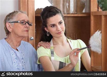 young woman helping senior lady with the cleaning