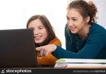 young woman helps a teen girl with homework