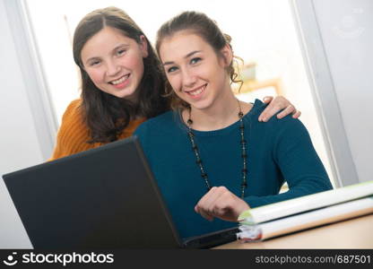 young woman helps a teen girl with homework