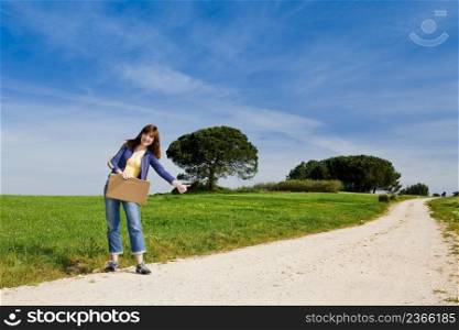 Young woman hitch hiking on a beautiful green meadow