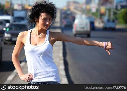 young woman hitchhiking on highway
