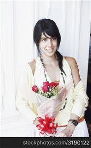 Young woman holding a bouquet of flowers and smiling