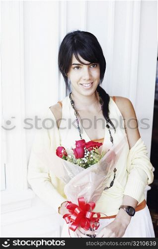 Young woman holding a bouquet of flowers and smiling