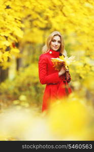 Young woman holding a bunch of autumn leaves