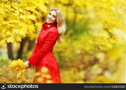Young woman holding a bunch of autumn leaves