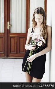 Young woman holding a bunch of flowers and smiling