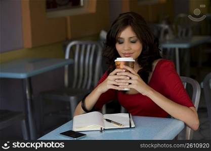 Young woman holding a cup of cold drink in a cafe
