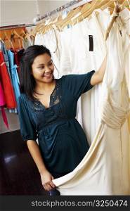 Young woman holding a dress in a clothing store