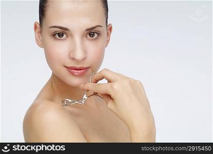 Young woman holding a eyebrow tweezers